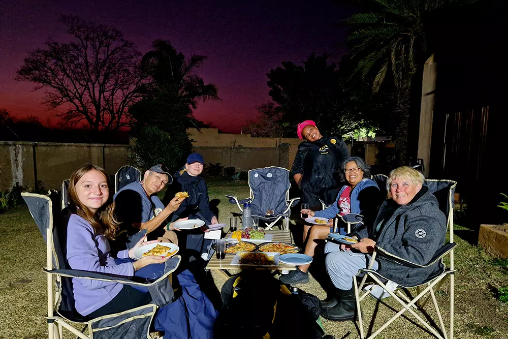Volunteers Having Dinner Against Beautiful Sky