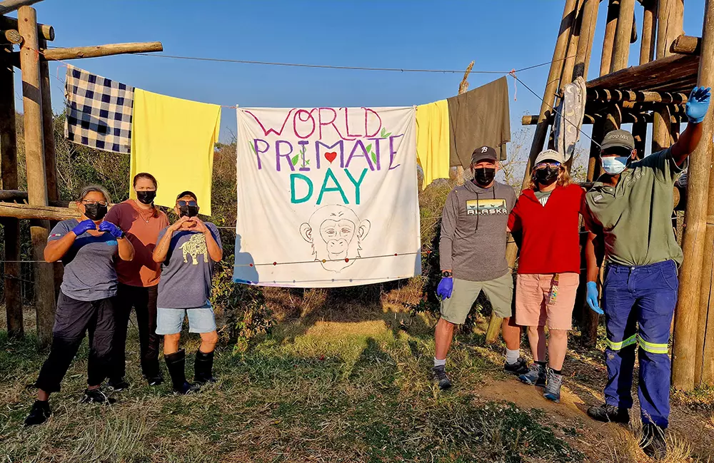 Volunteers Standing Around World Primate Day Banner They Made